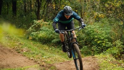 a man riding a bike down a dirt road