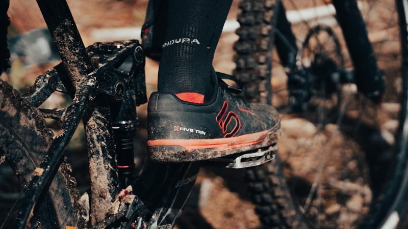 A dynamic shot of a cyclist's shoe on a muddy mountain bike pedal, emphasizing adventure and outdoor biking.
